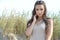 Stylish emotional girl in silver jewelry. Amazing curly brunette stands on the sand. Hair fluttering in the wind