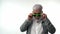 Stylish emotional old man pensioner with a gray beard in green glasses dances with funny emotions on a white isolated