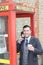 Stylish ethnic gentleman calling from vintage payphone