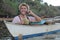 Stylish ethnic male calling by phone from a boat while drinking a fresh coconut