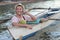 Stylish ethnic male calling by phone from a boat while drinking a fresh coconut