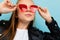 Stylish european girl in glasses on a light blue studio wall