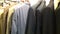 Stylish expensive men`s business suits for sale. Clothes on hangers. Fashion for managers and businessmen concept. Premium store.
