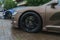 Stylish and expensive sports car closeup. Raindrops on a beautiful brown car.