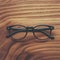 Stylish eyeglasses with black frames set against natural wooden background