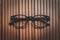 Stylish eyeglasses with black frames set against natural wooden background