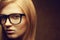 Stylish eyewear concept. Portrait of a young beautiful red-haired model (student) wearing trendy glasses and posing over golden b