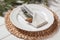 Stylish festive place setting with plate, cutlery and fir branches on white wooden table, closeup