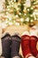 stylish festive socks on couple legs on background of golden beautiful christmas tree with lights in festive room. family relax t