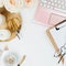 Stylish flatlay frame arrangement with pink laptop, candles, roses, glasses on white