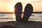 Stylish flip flops on sand. Beach accessories
