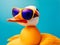 stylish funny duck with orange beak wearing sunglasses looking away against blue background -