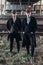 Stylish gangsters men, posing on background of railway. england in 1920s theme. fashionable brutal confident group. atmospheric m