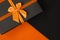 A stylish gift box on duotone orange and black background with copy space