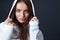 Stylish Girl. Beautiful Model Close Up Portrait. Sensual Brunette Putting Hood On Head. Young Woman In White Hoodie