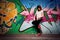 Stylish girl in a dance pose against graffiti wall