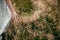 Stylish girl in linen dress gathering herbs and wildflowers in field, hand close up. Boho woman walking in countryside among grass