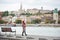 Stylish girl walks along embankment of Budapest with blurred view