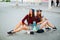 Stylish girlfriends sitting on skateboard at street.