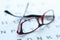 Stylish glasses in black and red frames lie on ophthalmic table closeup