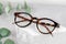 Stylish glasses on a podium made of natural stone. Leopard-colored glasses and plants