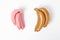 Stylish gold and pink bananas on white background