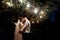 Stylish gorgeous bride and elegant groom standing under tree wit