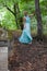 Stylish gorgeous girl in dress in summer forest. Fairy in the magic forest in summer.