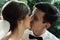 Stylish gorgeous happy bride and groom kissing at wedding reception, emotional cheerful moment