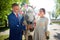 Stylish groom in a blue suit walk with the bride in a white dress in nature in the park with white horse. Wedding