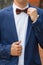 Stylish groom straightens a tie .