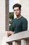 Stylish hair young man outdoors on the ledge, tight knit