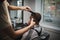A stylish hairstylist serving client on a barbershop background. Hairdresser`s hands shaving male client`s head. Beauty