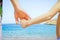 Stylish hands of a parent and child on the sea shore background