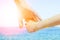 Stylish hands of a parent and child on the sea shore background