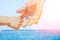 Stylish hands of a parent and child on the sea shore background