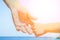 Stylish hands of a parent and child on the sea shore background