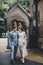 Stylish happy bride and groom walking on background of church in sunny street. Provence wedding. Beautiful emotional wedding