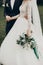 Stylish happy bride and groom walking in yard and holding hands at wedding ceremony. romantic moment, space for text. luxury