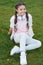 Stylish happy child relax on green grass. little girl listen music. Spring mood. Mp3 player. happy little girl. Audio