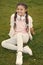 Stylish happy child relax on green grass. little girl listen music. Spring mood. Mp3 player. happy little girl. Audio