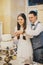 Stylish happy wedding couple cutting together modern cake with lavender in stylish restaurant. Provence wedding reception.