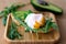 Stylish healthy breakfast of an avocado, arugula and poached egg toast on a wooden surface