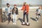 Stylish hipster boy riding gyroboard with friends near by