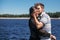 Stylish hipster couple gently hugging at windy river in summer c