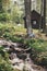 Stylish hipster traveler sitting at river in forest on background of wooden log in mountains. Exploring woods in summer. Copy