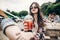 stylish hipster woman in sunglasses with red lips holding lemonade. cool boho girl holding cocktail and sitting at street food fe