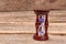 Stylish hourglass on wood background.