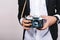 Stylish image of retro camera in hands of handsome guy in suit. Leisure, journalist, photograph, hobbies, having fun.