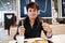 Stylish indian man sitting at fast food cafe and eating french fries